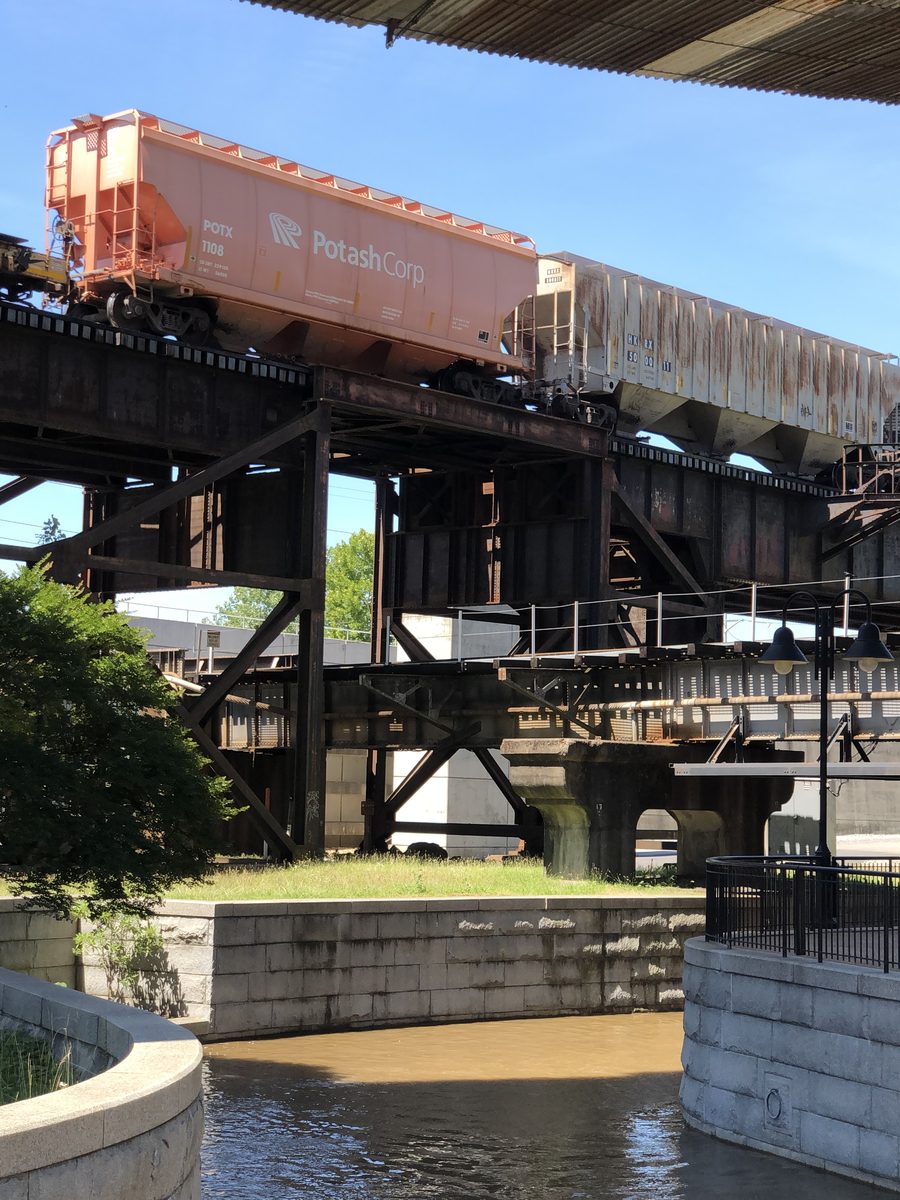 Freight cars crossing rail infrastructure beside Richmond’s canal