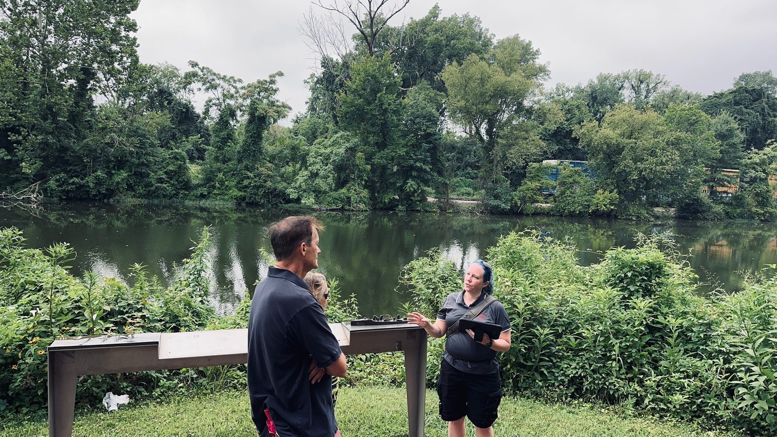 A guide and guests beside the James River and railroad tracks